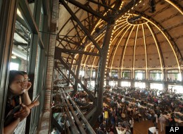 Two people watch undocumented people fill out application forms for the Obama administration's Deferred Action for Childhood Arrivals program on Wednesday at Navy Pier in Chicago. (AP Photo/Sitthixay Ditthavong)