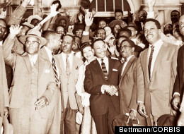 Rev. Martin Luther King, Jr., shaking hands with his lawyer, Arthur D. Shores, as they stand in front of cheering followers after King’s conviction for his part in the bus boycott in Montgomery, 1956.