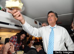 U.S. Republican presidential candidate Mitt Romney hands NBC producer Scott Foster a piece of cake as he celebrates his birthday aboard the Romney campaign plane en route to Boston on Sept. 14. (NICHOLAS KAMM/AFP/GettyImages)