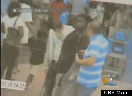 Lewis Jhon, in stripes, is shown in surveillance video detaining the shoplifting suspect.