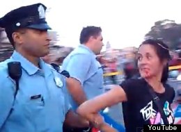 Aida Gusman is led away after allegedly being punched in the face by Philadelphia police Lt. Jonathan Josey.