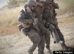 U.S. Marine lance corporal Zachary Densmor from 3rd Battalion, 7th Marines is carried by his comrades to a medevac helicopter after he was hit by an improvised explosive device (IED) in Helmand Province, Afghanistan on Oct. 31, 2011. (BEHROUZ MEHRI/AFP/Getty Images)