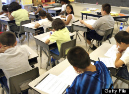 Arlene Lebowitz assists a student in her third-grade class during summer school July 2, 2003 in Chicago, Illinois. (Photo by Tim Boyle/Getty Images)
