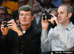 Thorsten Heins, left, CEO of Research in Motion, and Andrew Bocking, senior vice president, Software Product Management at Research In Motion, take a picture with their mobile devices during the Los Angeles Lakers and Phoenix Suns NBA basketball game at Staples Center on November 16, 2012 in Los Angeles, California. (Photo by Kevork Djansezian/Getty Images)
