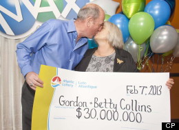 Gordon and Betty Collins of Placentia, N.L., kiss as they display their $30-million LOTTO MAX top prize cheque from the Jan. 25, 2013 draw in St.John's, N.L. on Thursday, Feb.7, 2013. THE CANADIAN PRESS/Graham Kennedy